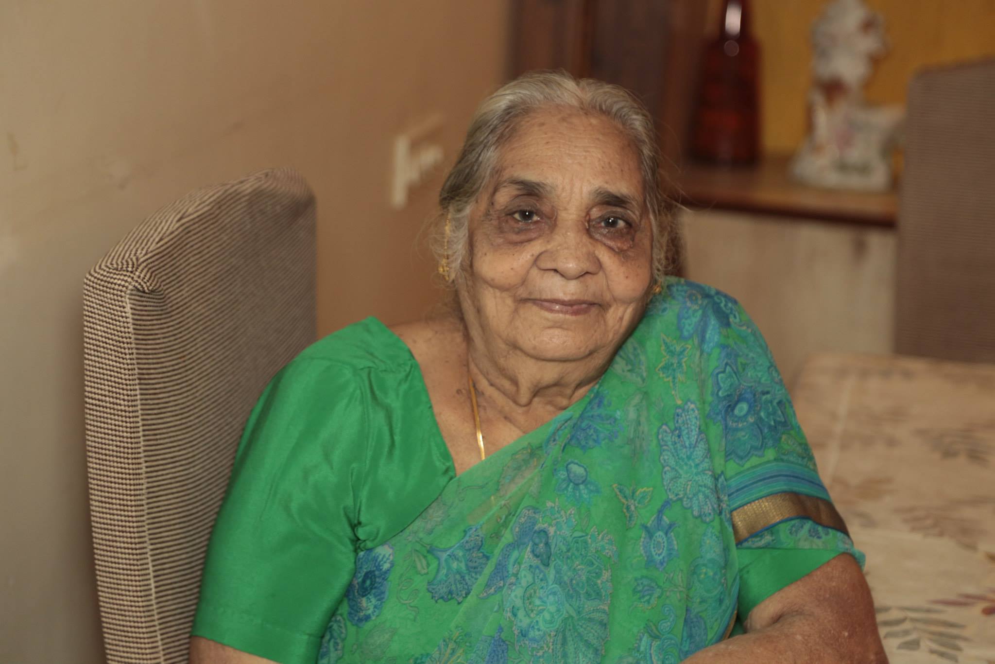 Darpavati Singh late mother of Nomita Iyengar seated at home in green saree