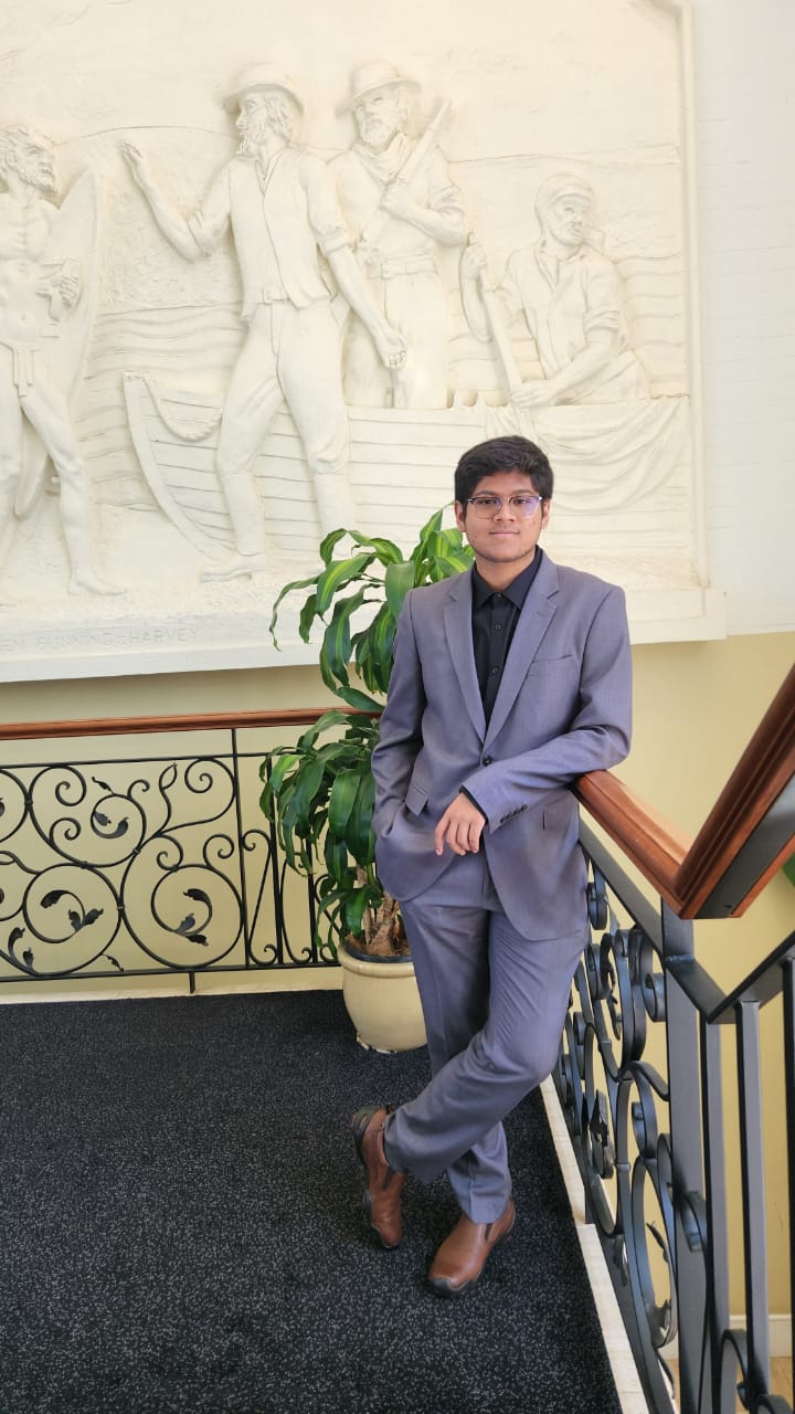 Phoenix Iyengar son of Carlon Iyengar Sydney Australia in grey suit on staircase